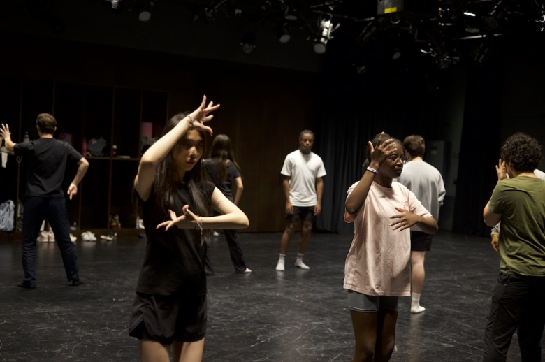 Tisch Summer High School Drama students stand and pose their arms in front of them in a drama studio